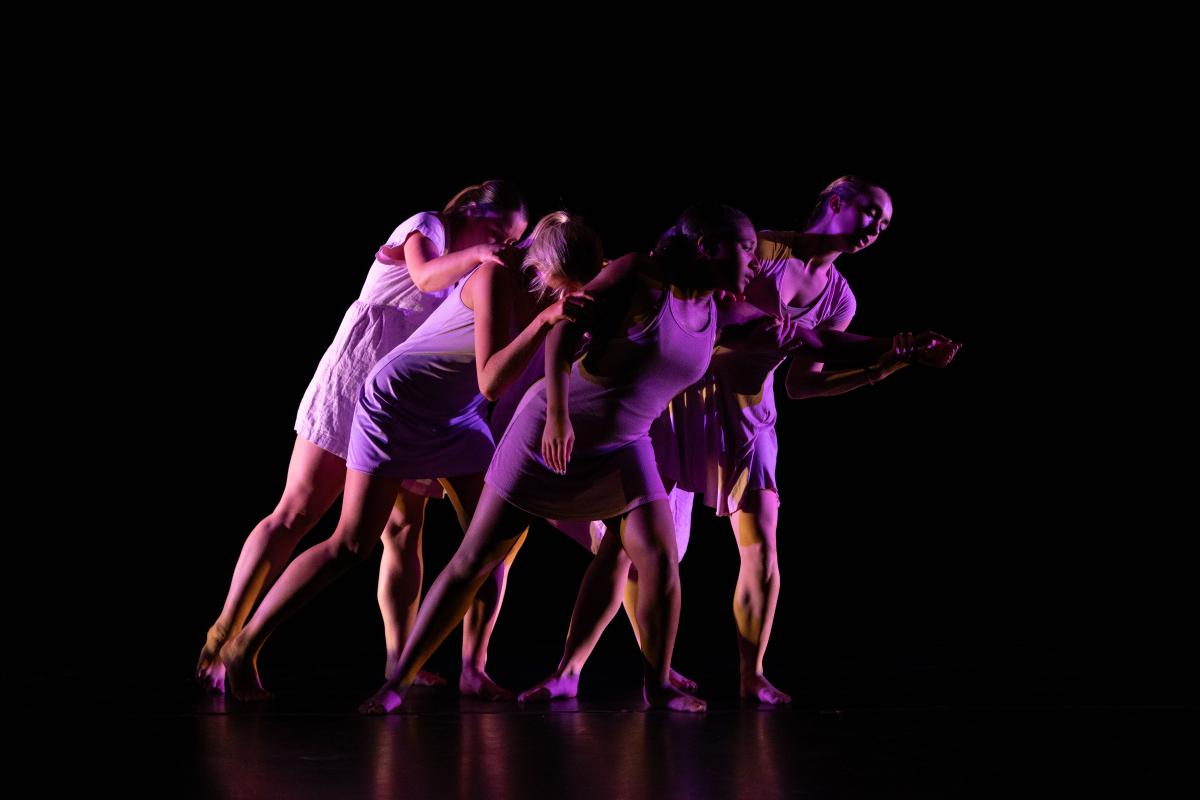 Group of dancers in a connected pose, leaning camera right.