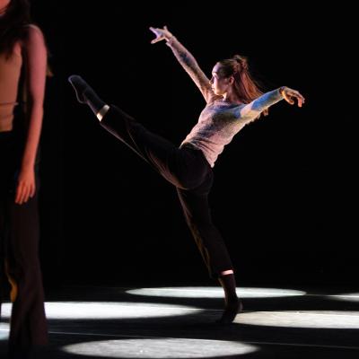 dancer at rest in front, dancer in motion behind, arms raised and one leg raised