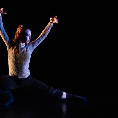singler dancer in pose on floor, legs out, arms raised