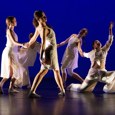five dancers with joined hands forming a circle with one link broken