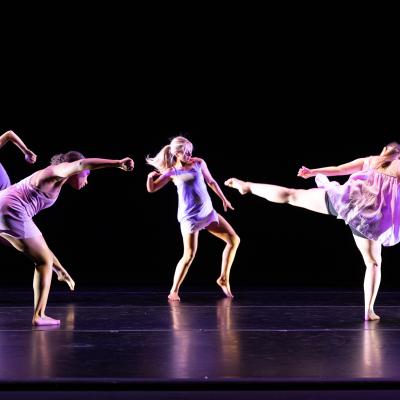 five dancers in motion in a circle in various poses