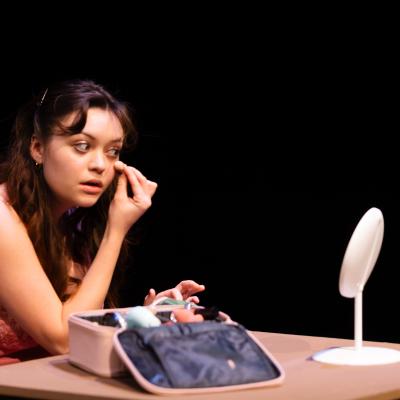 HATE MY SISTER: An actress fixing her makeup at a table with a mirror.