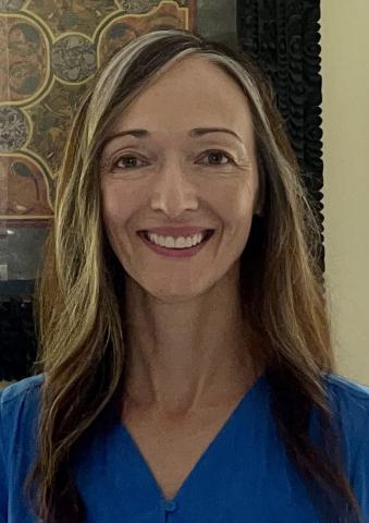 Woman facing the camera and smiling, stonework interior background